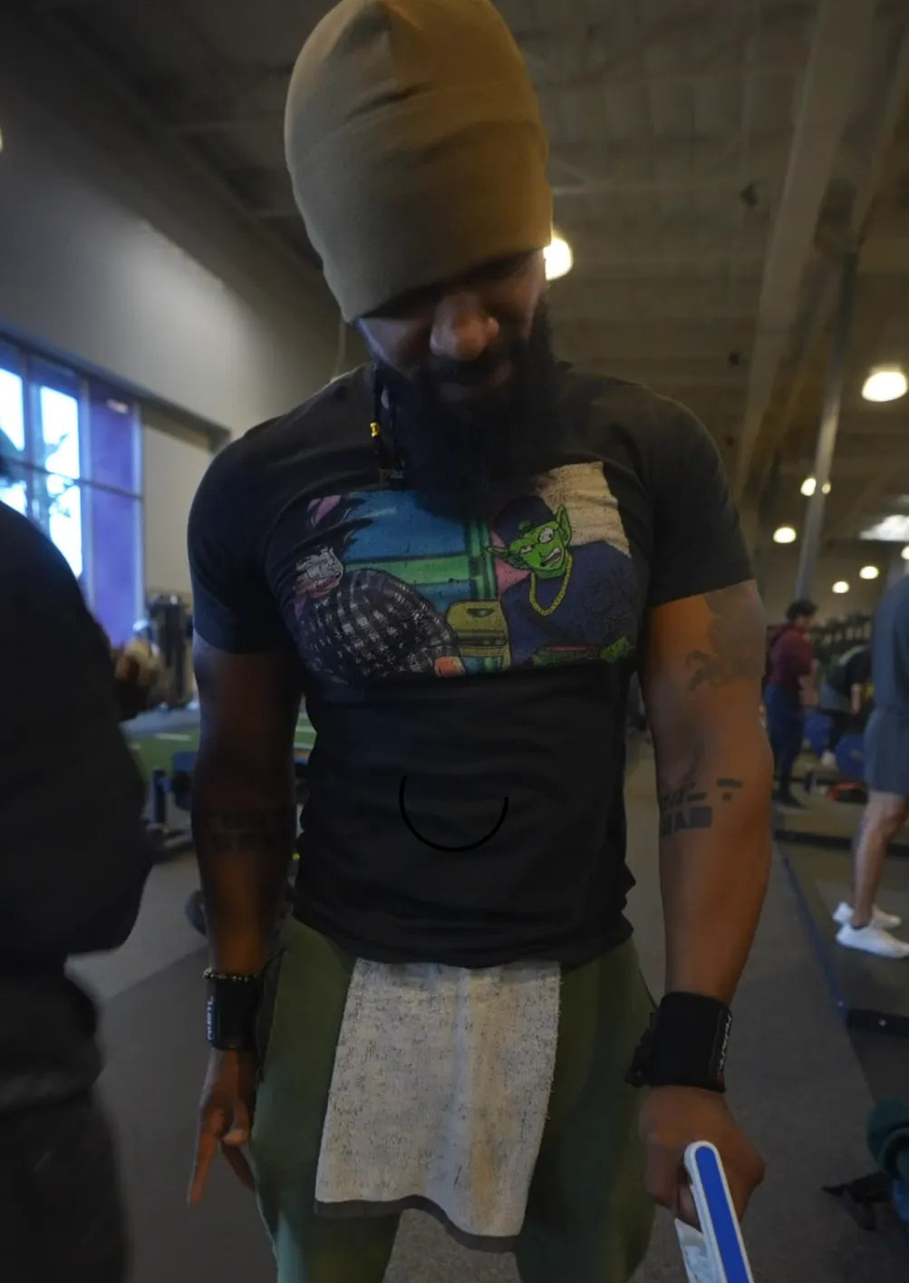 Man holding a Handexer digital hand dynamometer in a gym, showing grip strength testing during a fitness training session