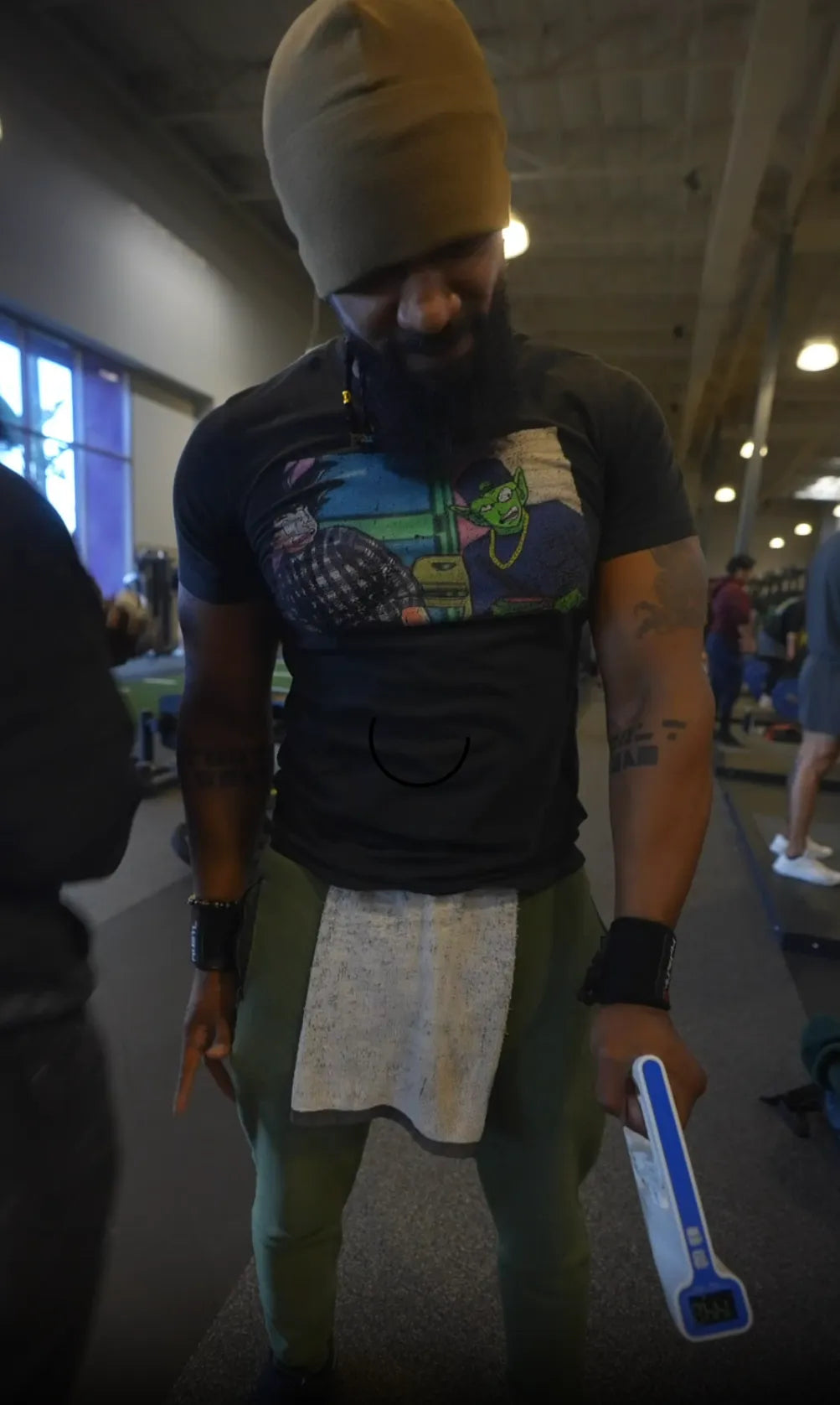 Man holding a Handexer digital hand dynamometer in a gym, showing grip strength testing during a fitness training session